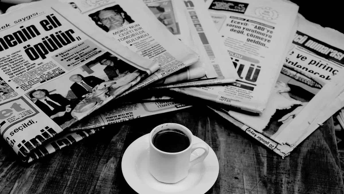A cup of turkish coffee sits on a wooden table next to a