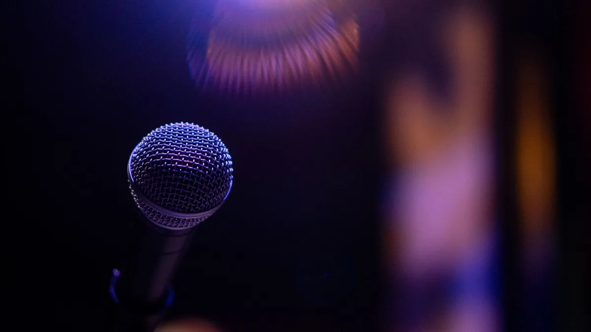 A dramatic close up of a microphone under a spotlight ev