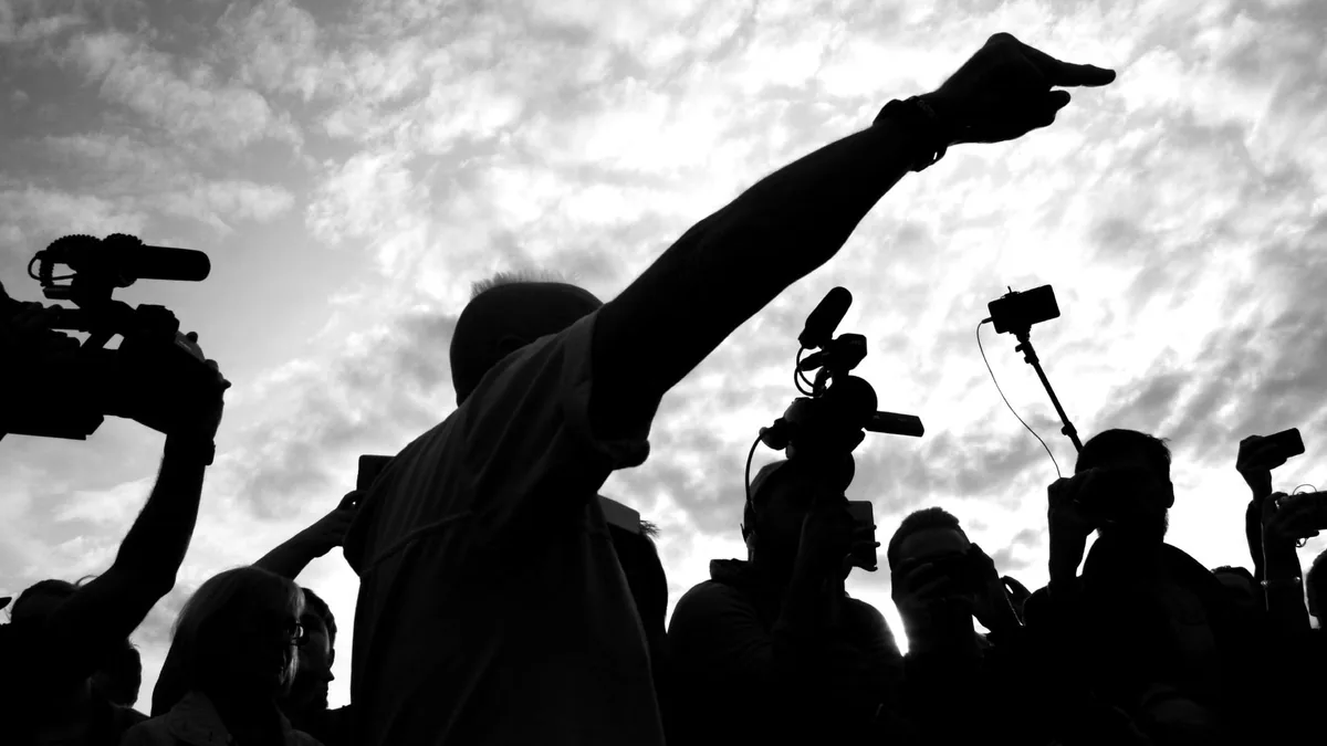 A dramatic silhouette of a media crew with cameras captu