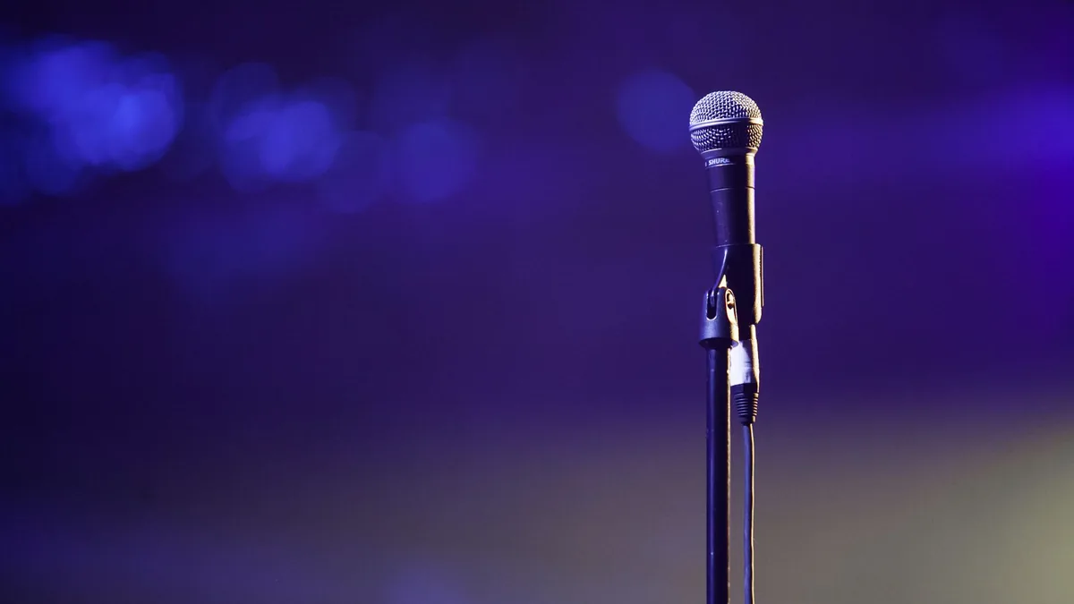 A dynamic photo of a microphone on a stand against a vib