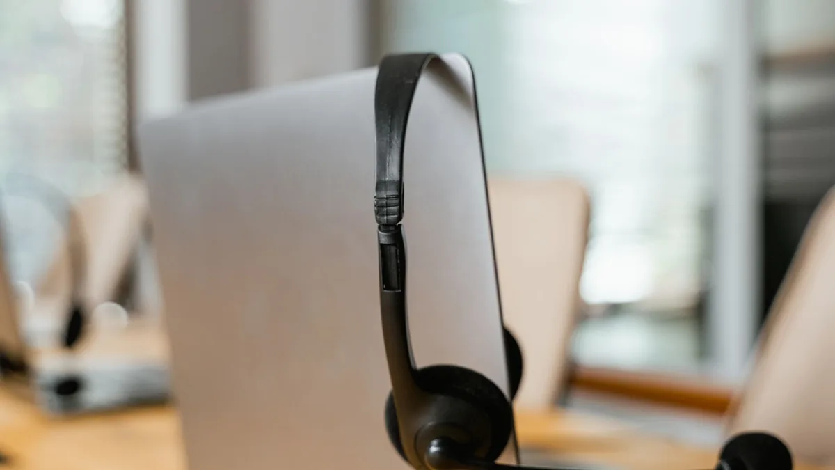 A headset hanging on a computer in a modern office setti