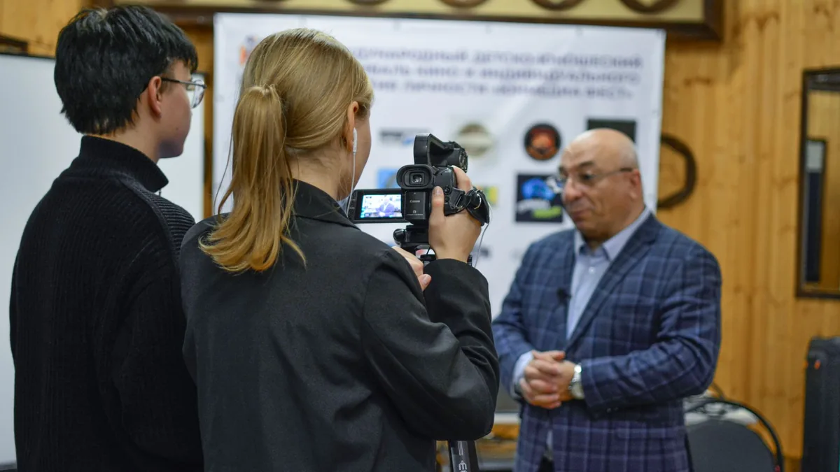 A journalist records an interview with a man using a cam