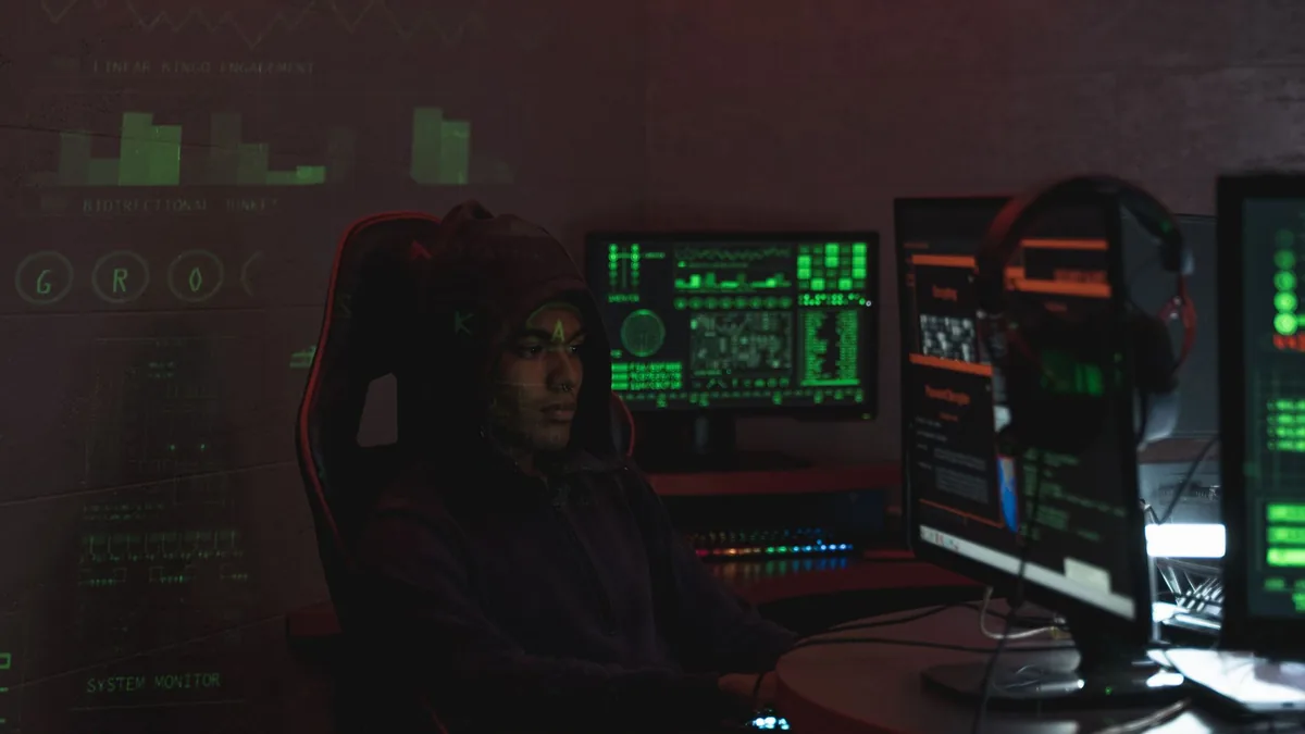 A man in a black hoodie engaged in cybersecurity work us