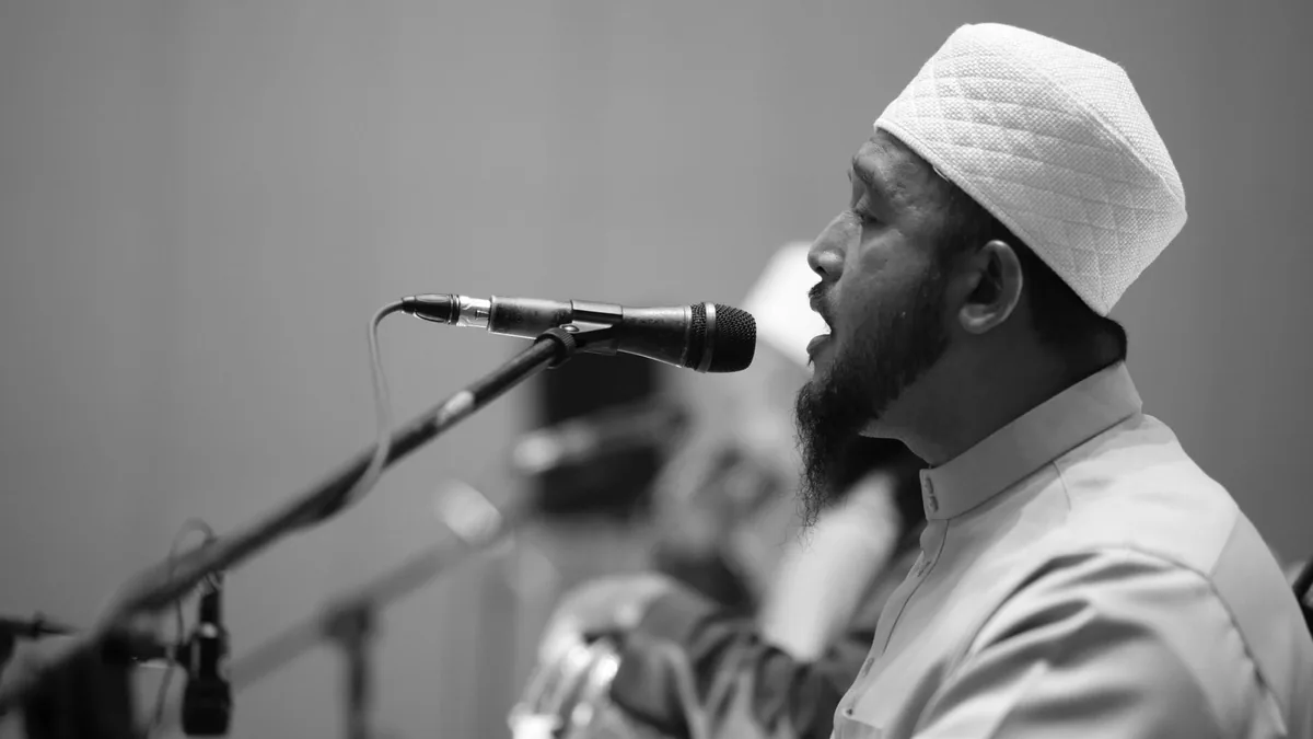 A man in traditional attire delivers a speech at an even