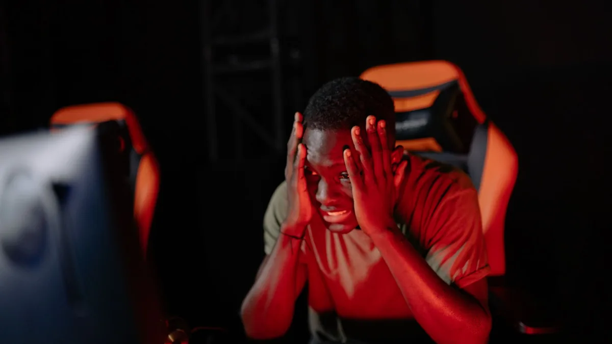 A man intensely reacts to a game loss at his computer in