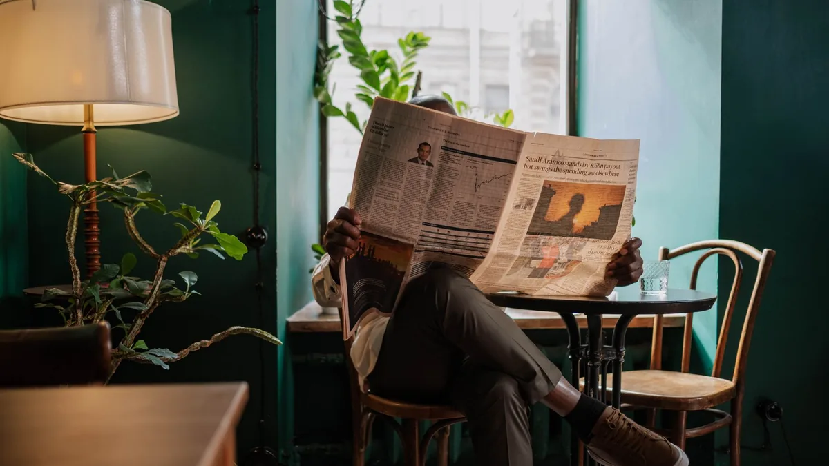 A man sits in a cozy caf corner enjoying a newspaper and