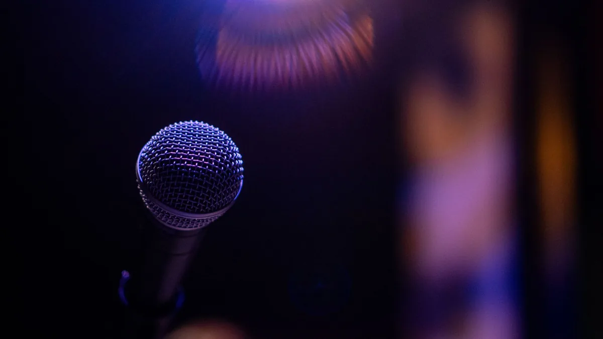 A microphone is spotlighted against a dark blurred backg