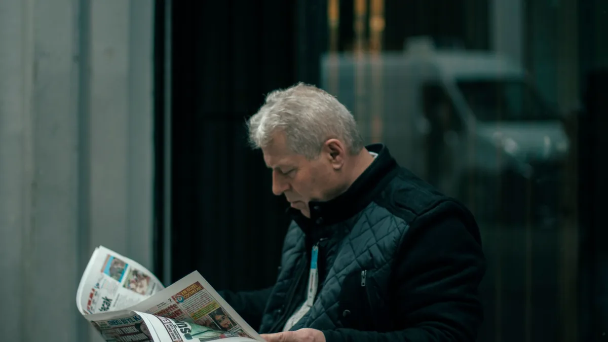 A middle aged man reads a newspaper in istanbul turkey r