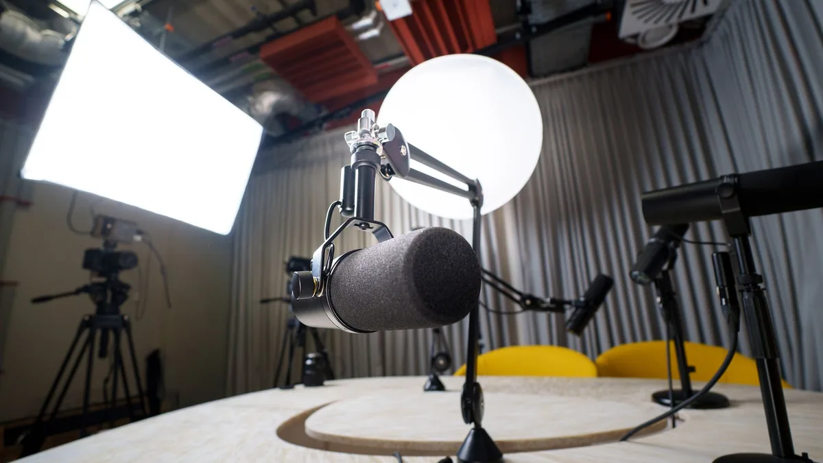 A modern podcast recording studio with microphones chair