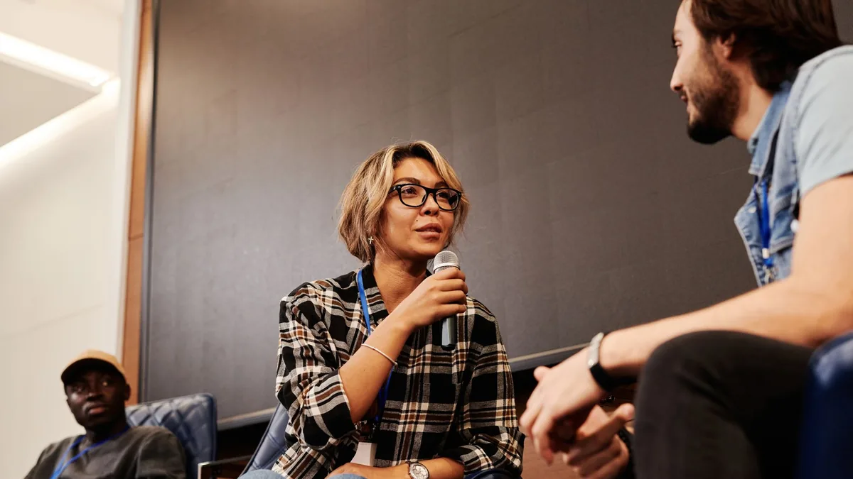 A multicultural group of adults engage in a lively panel