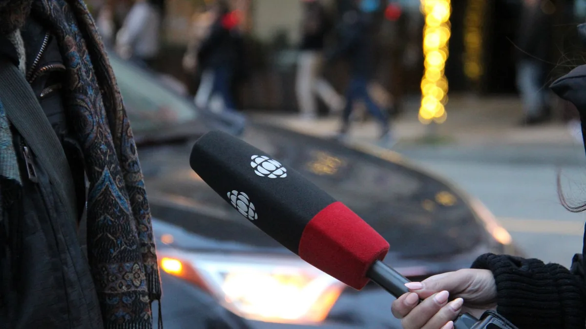 A person being interviewed on a vancouver street holding