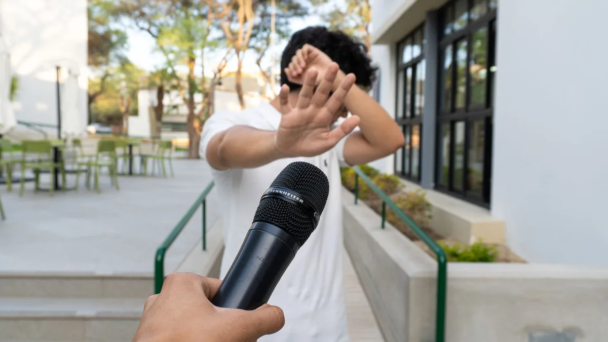 A person outdoors in piura avoiding a microphone signali