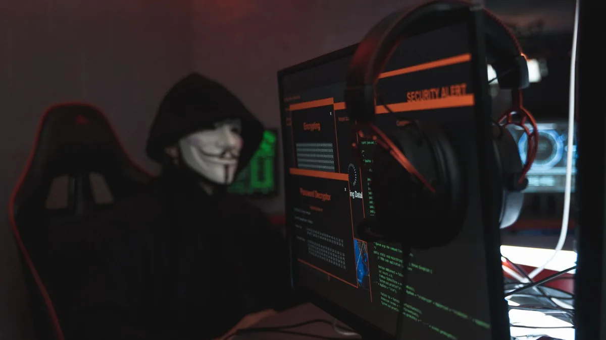 A person wearing a guy fawkes mask engaged in hacking ac