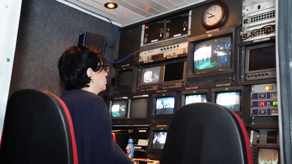 A professional in a tv broadcast control room with multi