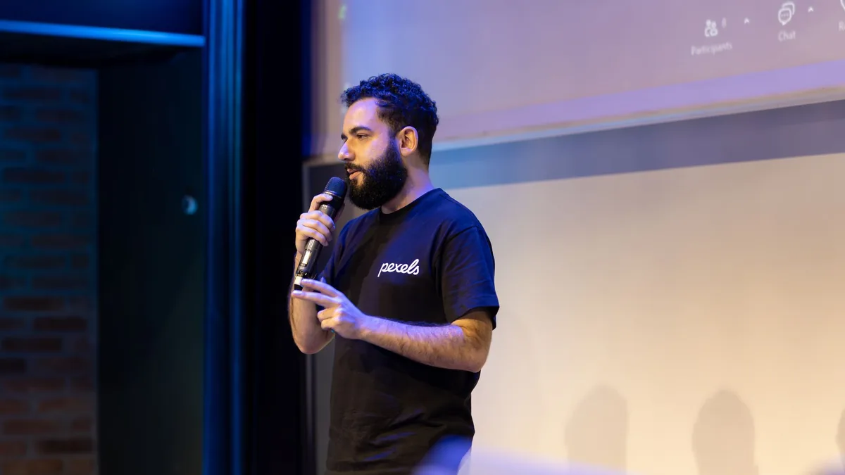 A speaker using a microphone during a presentation on st