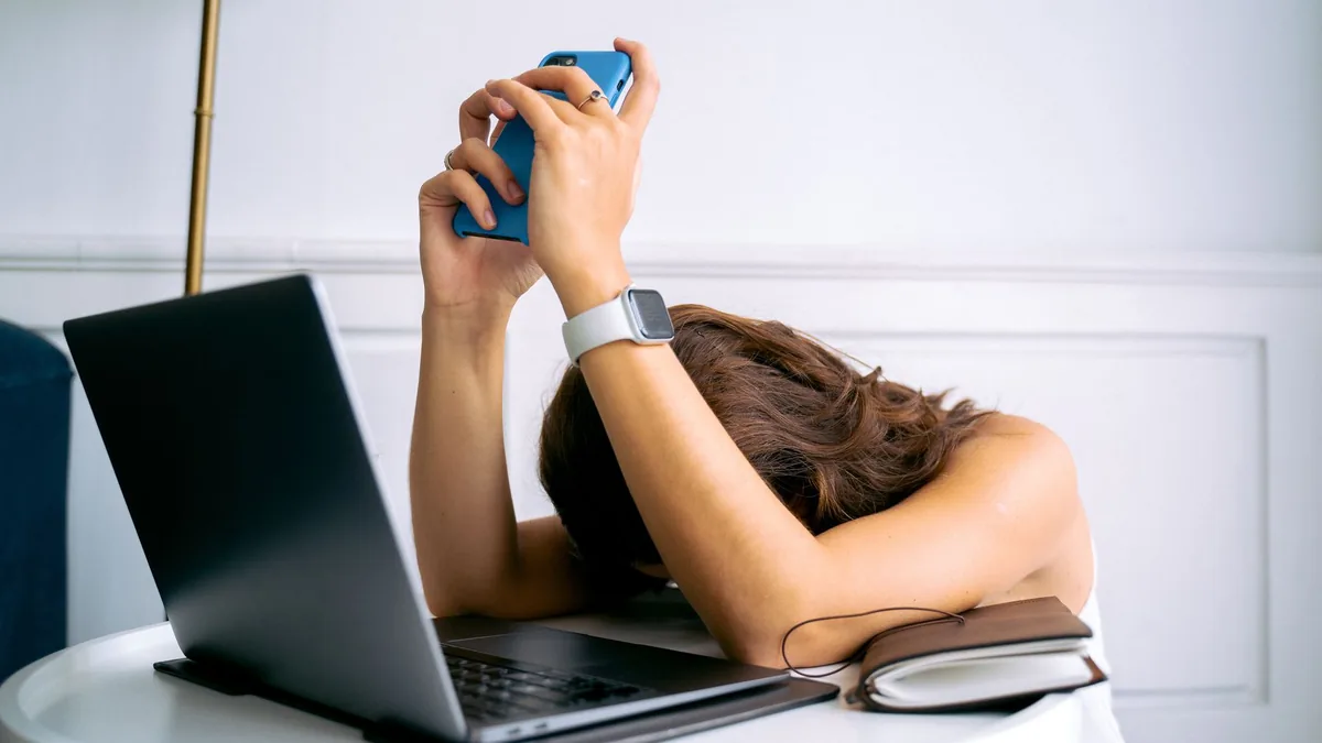 A woman overwhelmed by work resting head on table with l