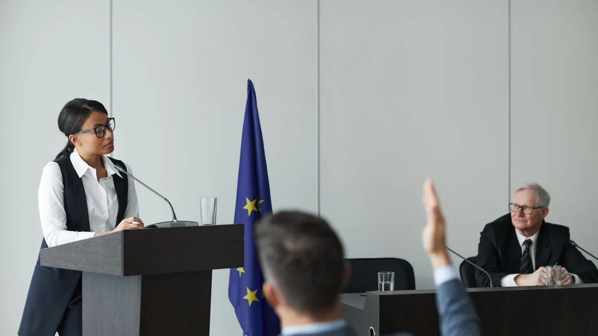 A woman speaking at a european union conference while de