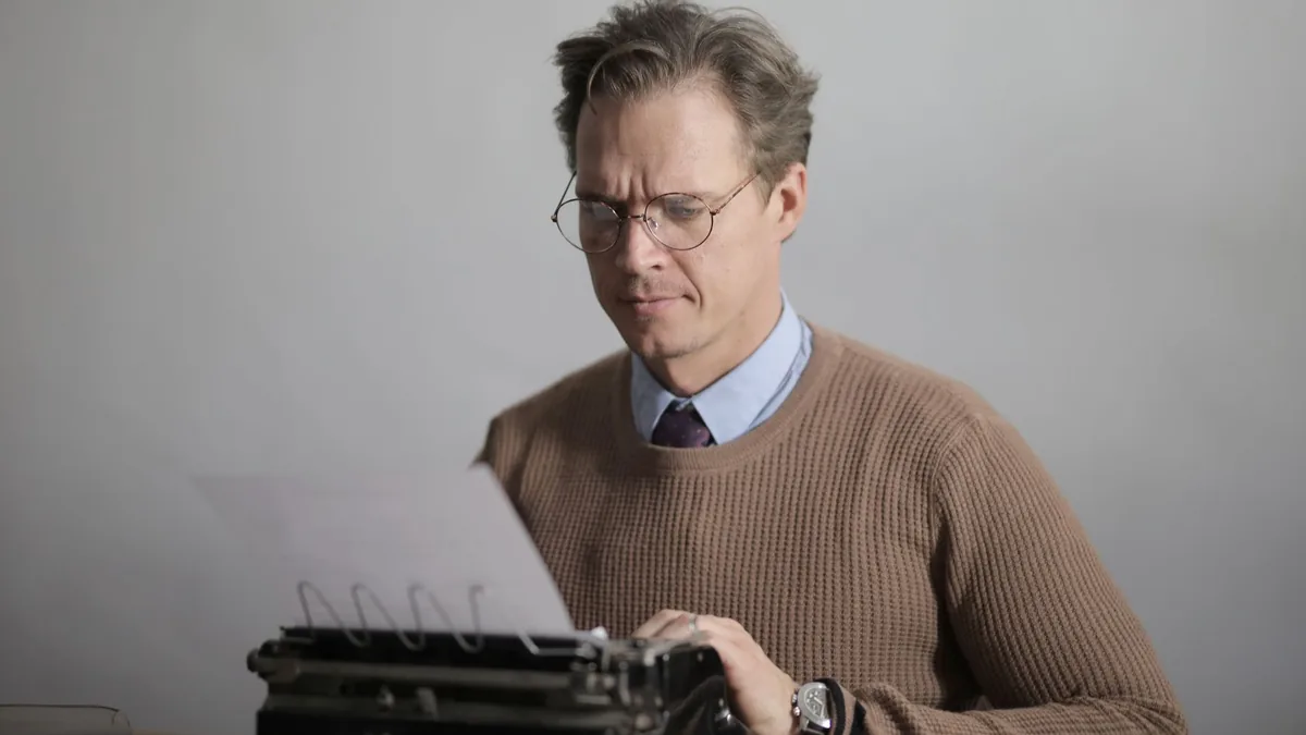 A writer concentrating while typing on a vintage typewri