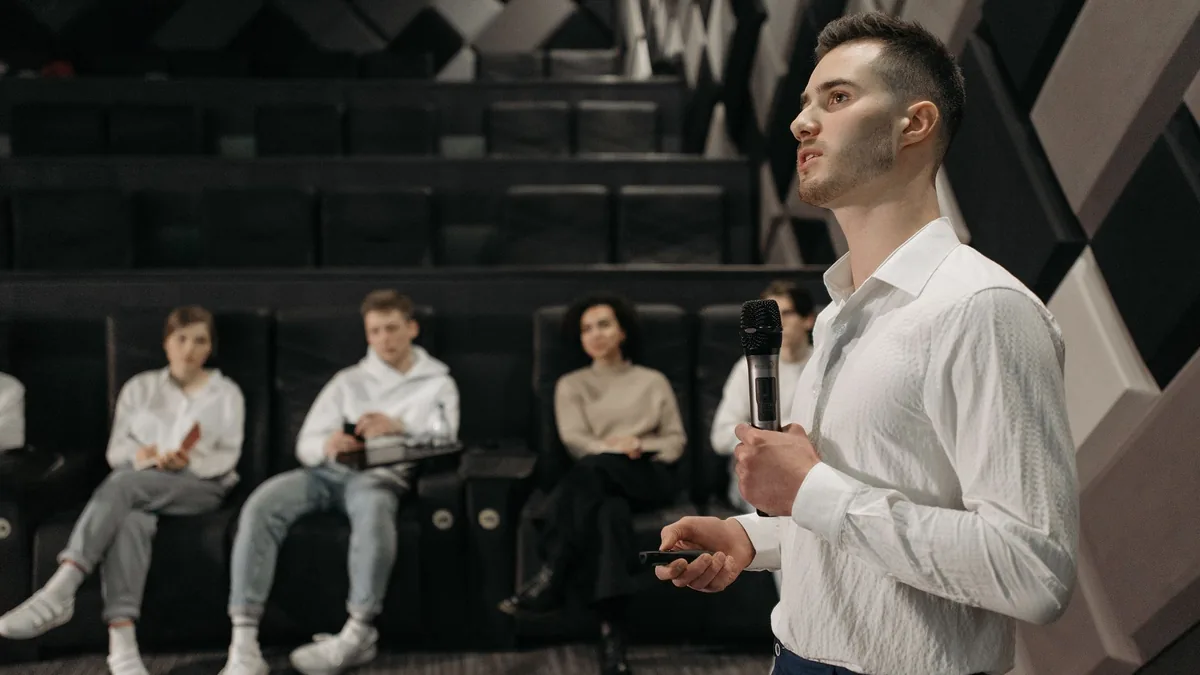 A young man delivers a presentation to a small group in