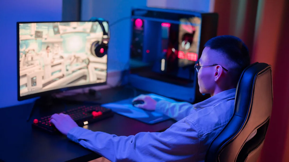 A young man intensely gaming on a computer at home showc
