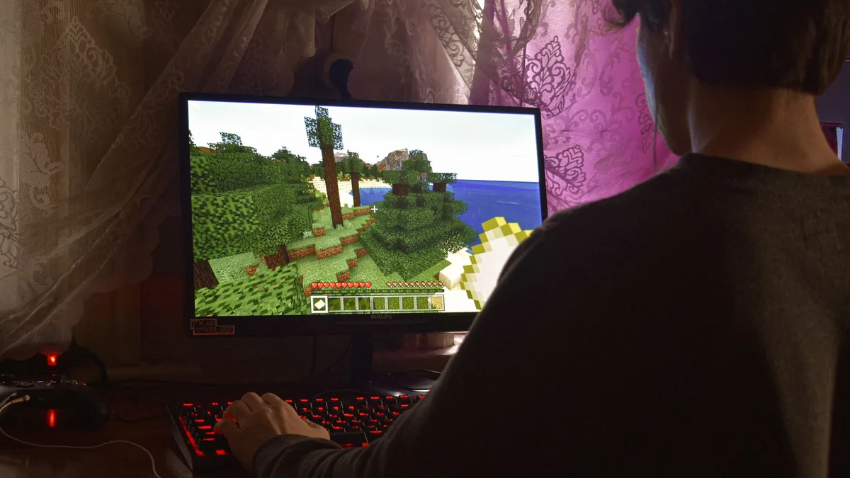 A young man intensely playing a pc video game indoors ca