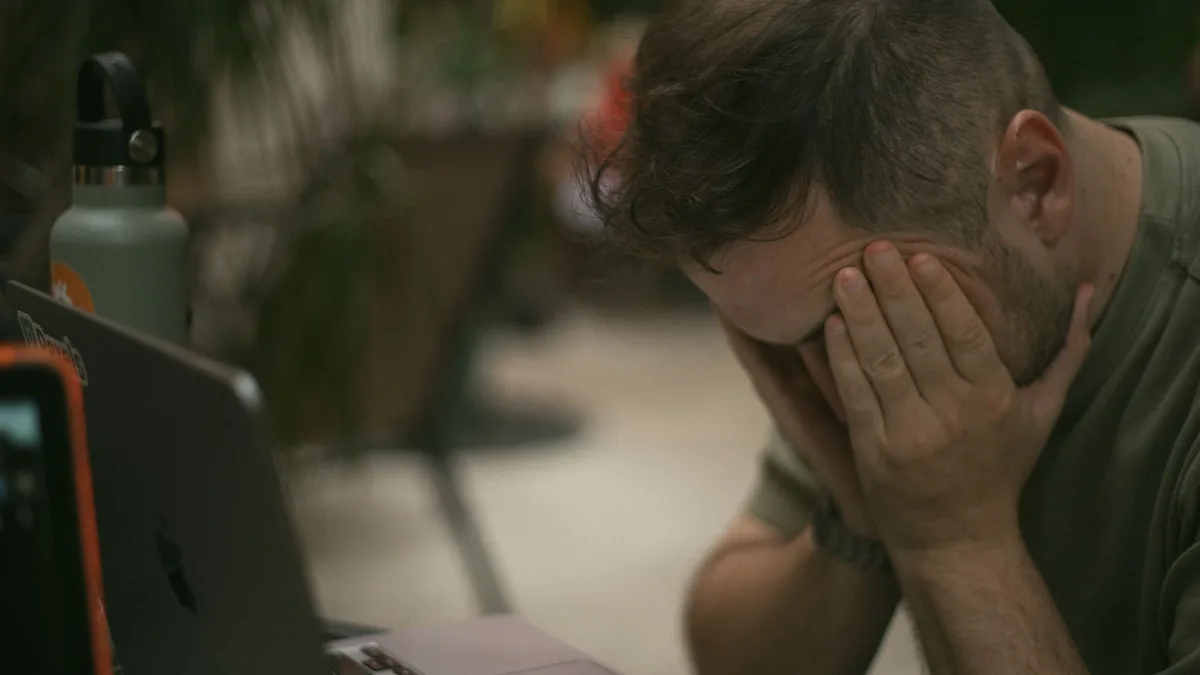 Adult male appears stressed sitting indoors with his han