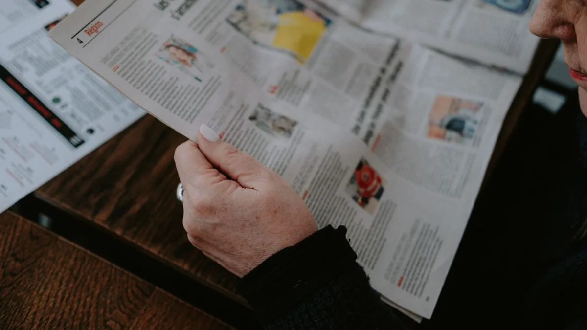 Adult reading a newspaper indoors captures focus and int