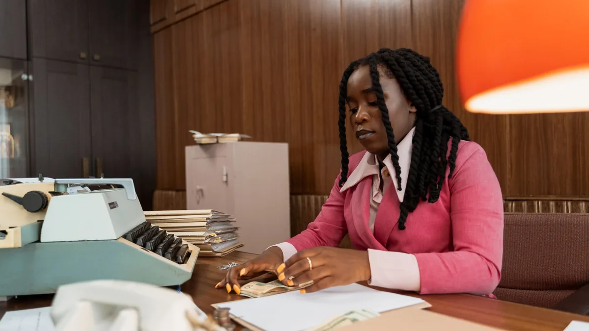 African american woman in business attire counting money