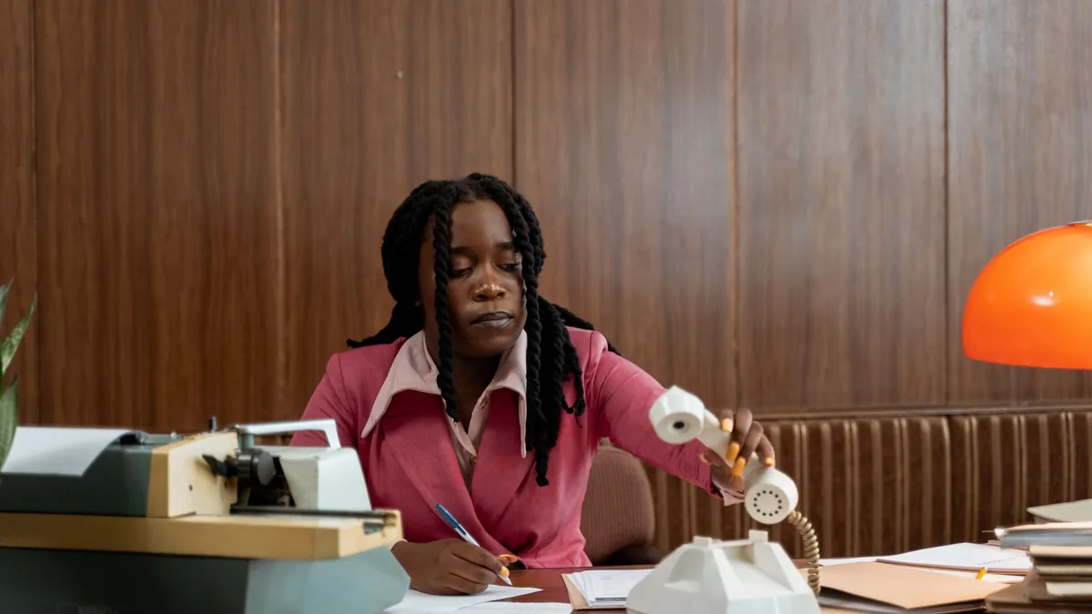 An adult woman in a vintage office setting handling a ro
