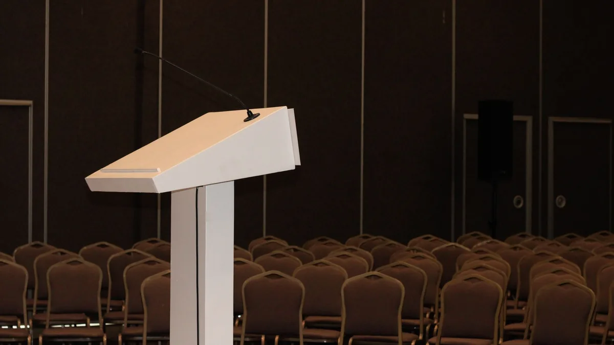 An empty conference room setup with podium and rows of c