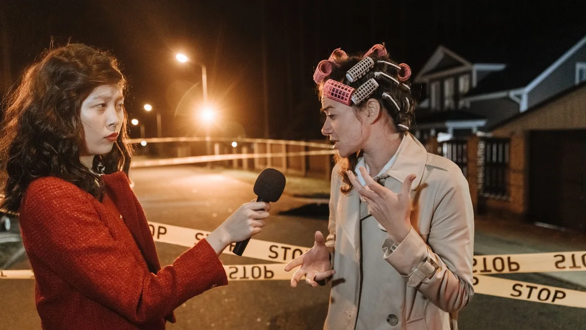 Asian female journalist interviews a woman at a night cr