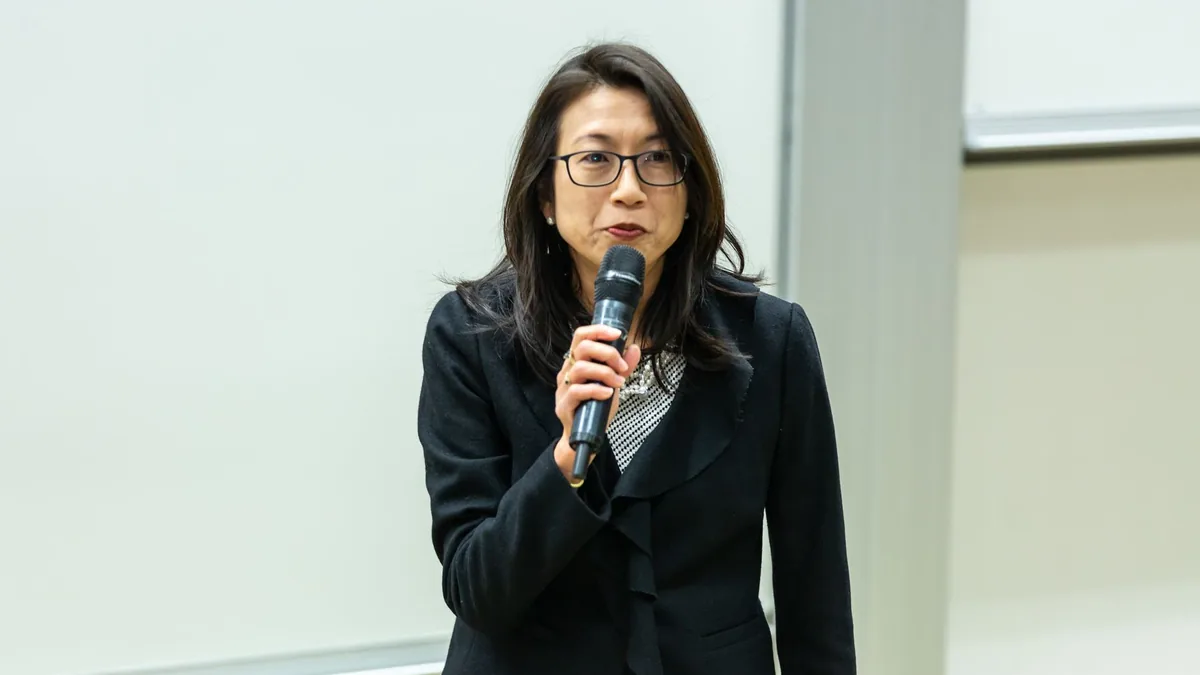 Asian woman in a professional attire giving a talk in a