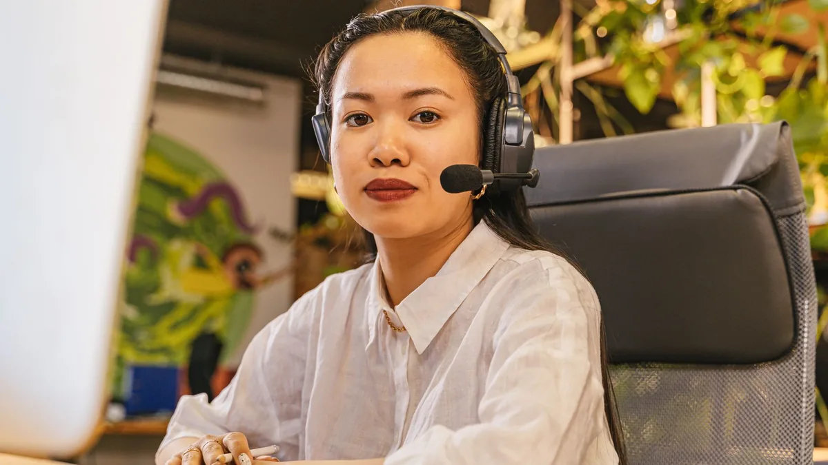 Asian woman in office wearing headset working in a moder