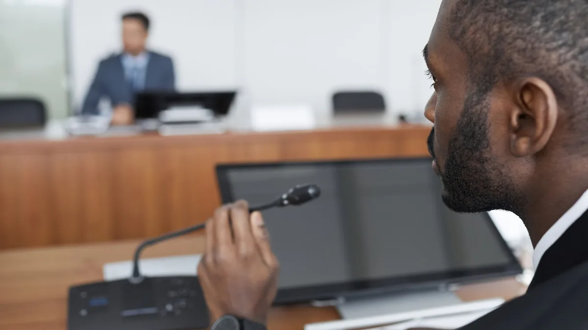 Bearded businessman speaks into microphone during office