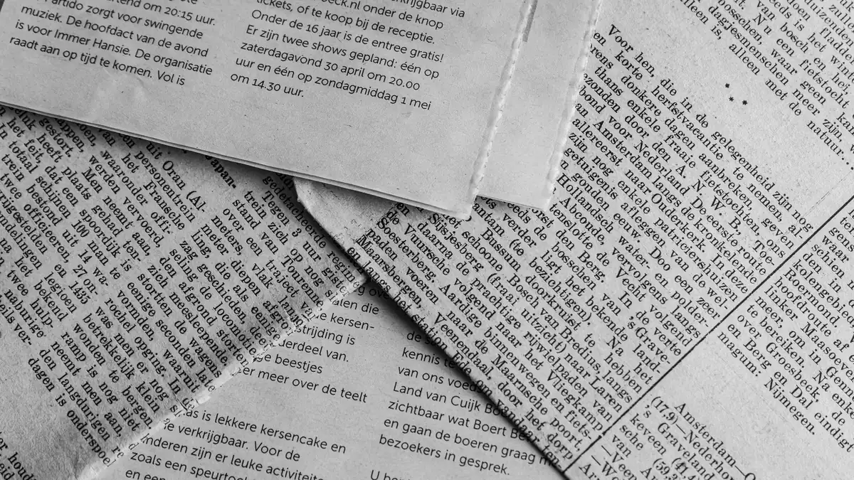 Black and white close up of newspaper pages with text in