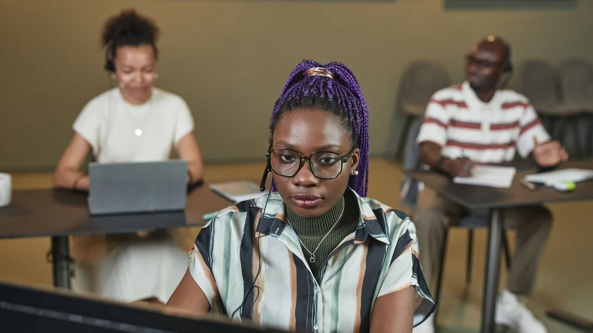 Black woman working with headset at office colleagues in
