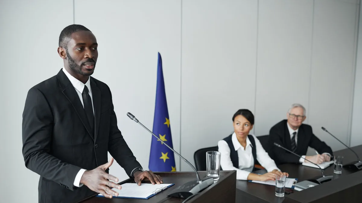 Business professional delivering speech in conference wi