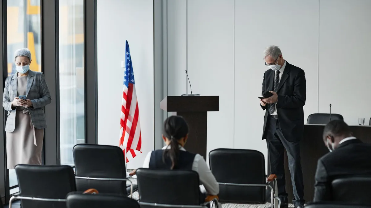 Business professionals in masks at a socially distanced