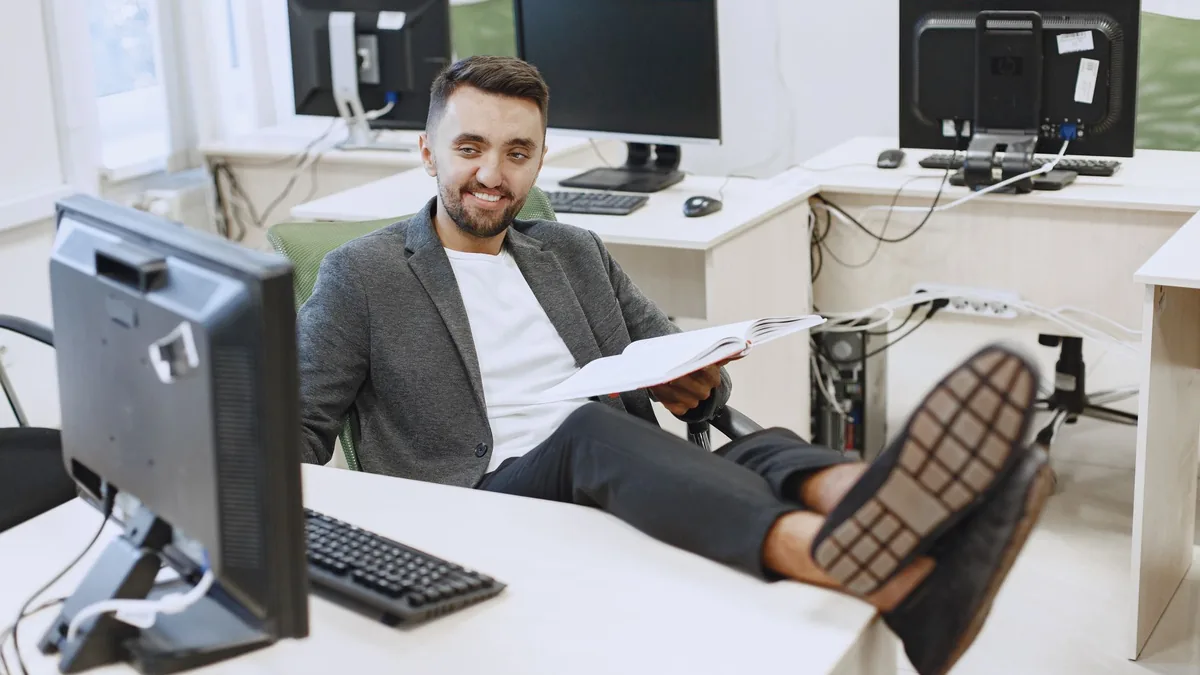 Businessman in casual office setting relaxing at his des