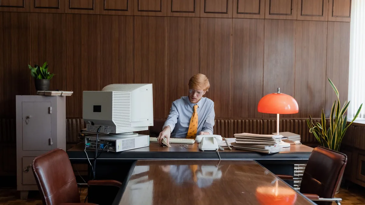 Businessman working in a retro office with vintage compu