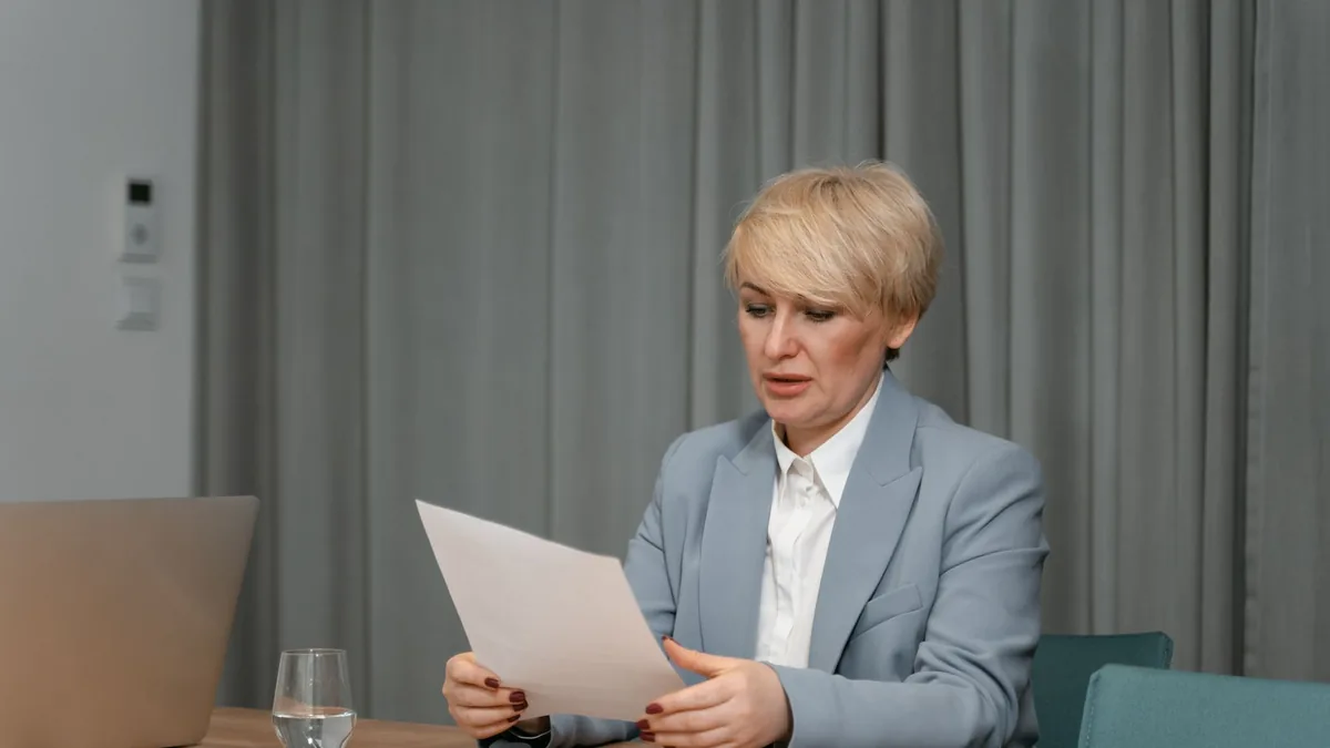 Businesswoman in a blazer reviewing documents at a desk
