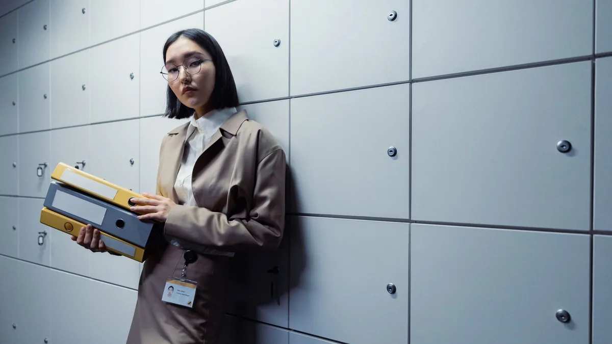 Businesswoman in office attire standing with documents a