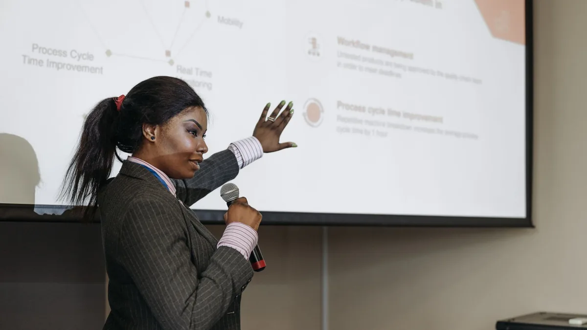 Businesswoman presenting with microphone discussing impr
