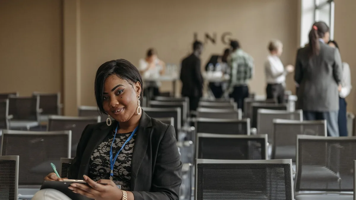 Businesswoman smiling while taking notes at a conference