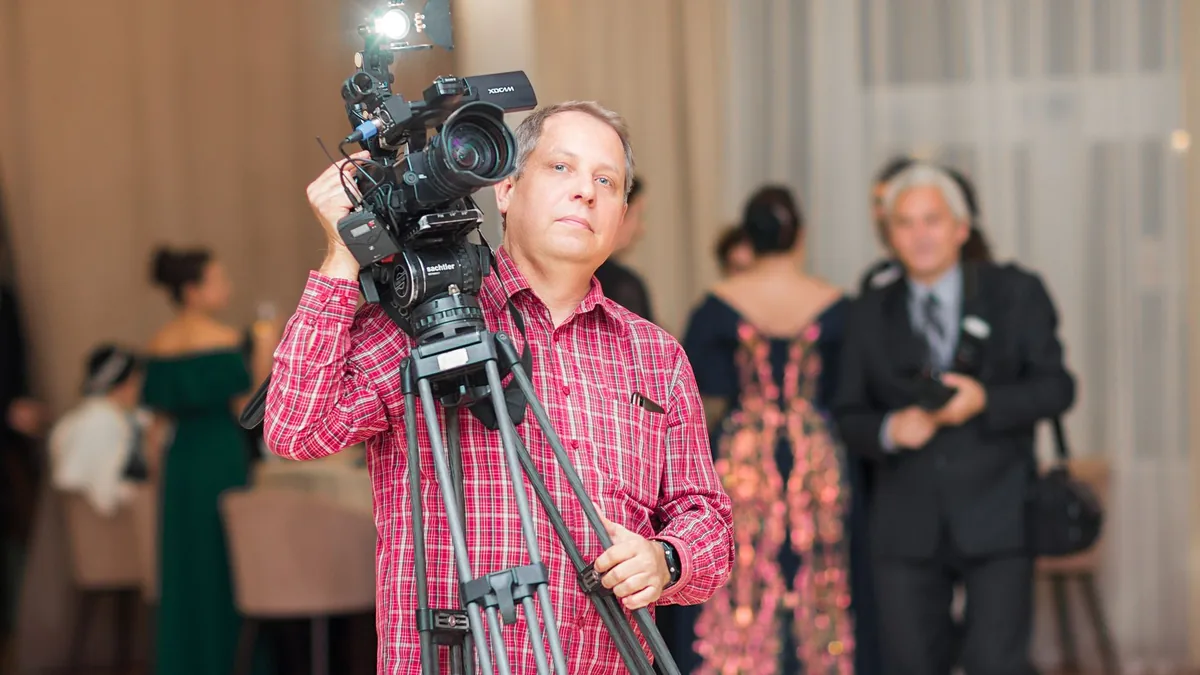 Cameraman capturing moments at a formal indoor event wit
