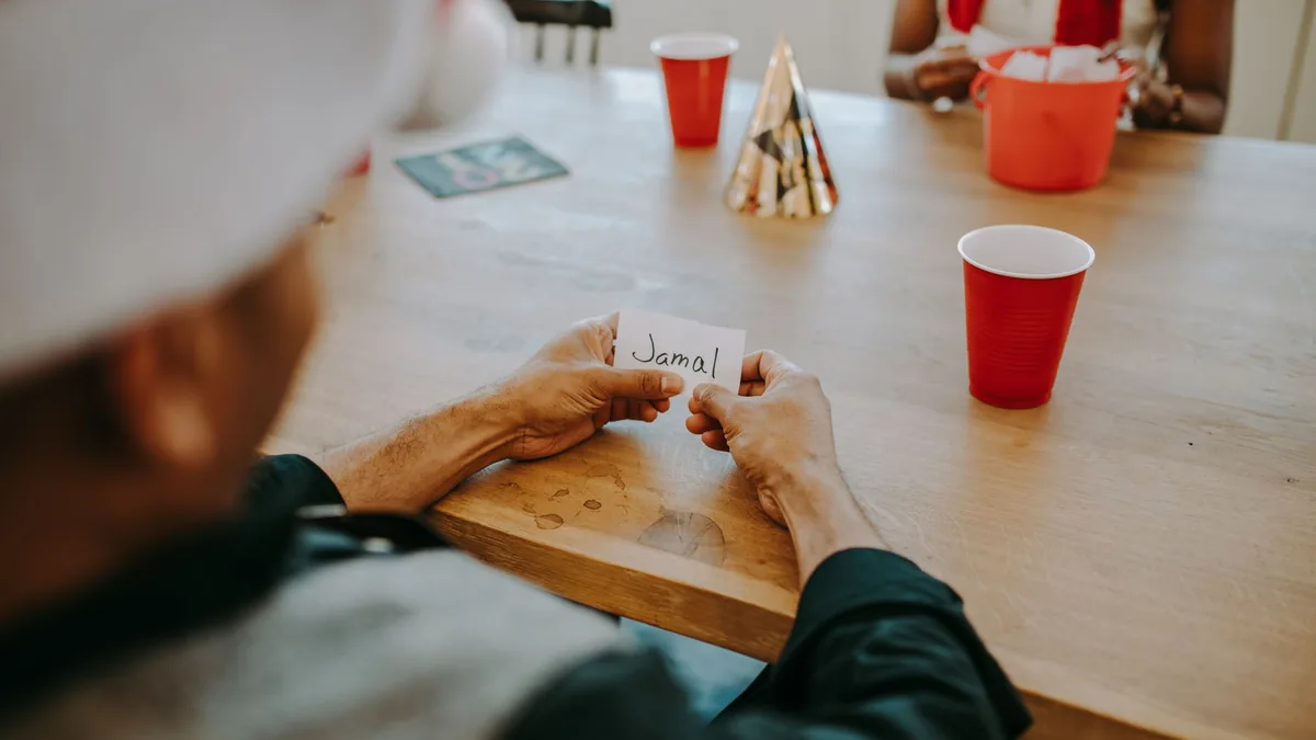 Casual indoor gathering scene with friends holding name