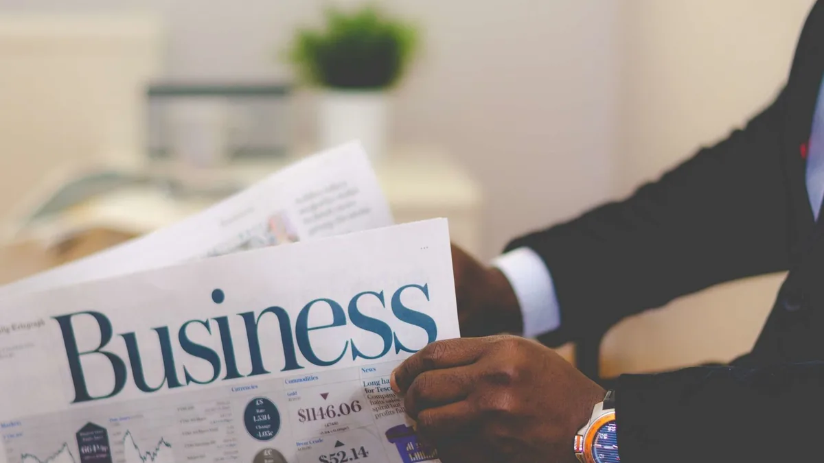Close up of a businessman reading a newspaper indoors fo