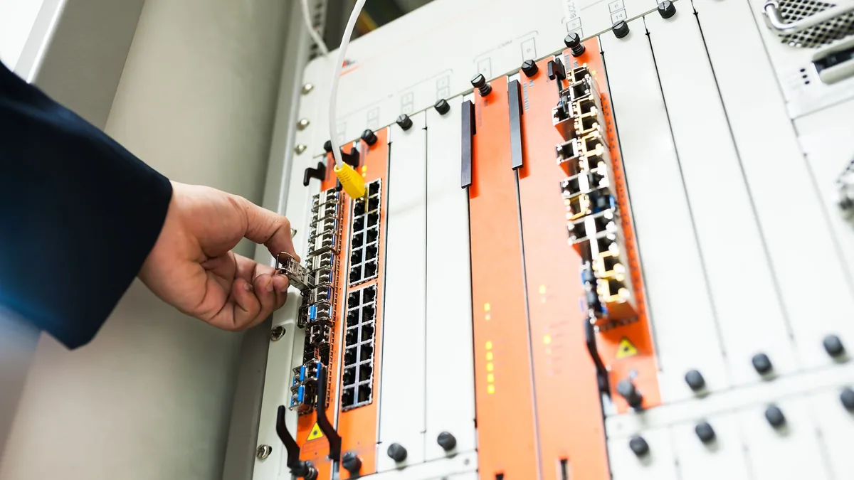 Close up of a hand adjusting network equipment in a data