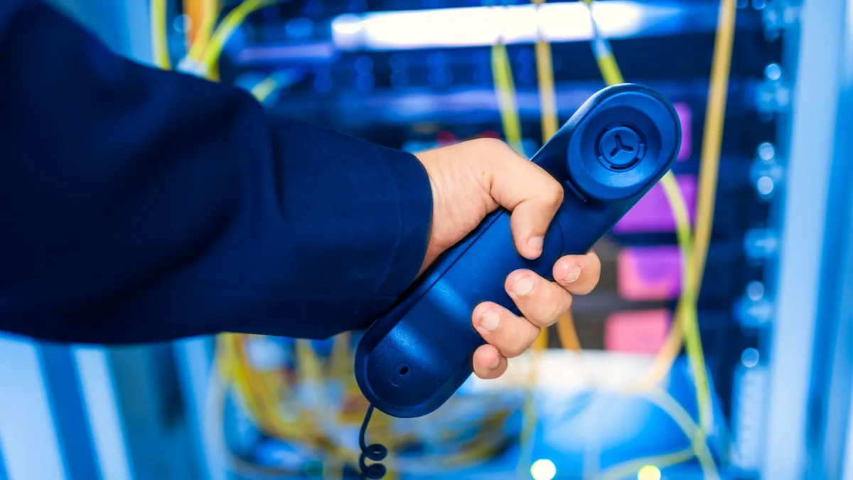 Close up of a hand holding a telephone receiver in a ser