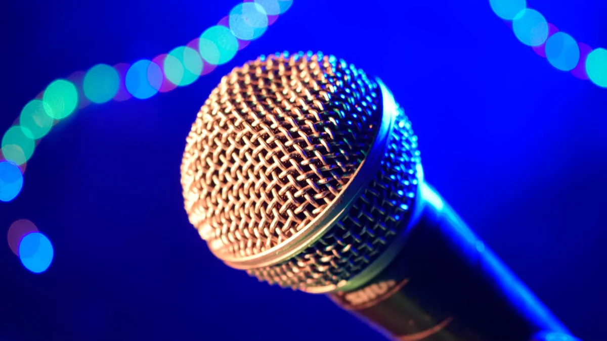 Close up of a microphone against a vibrant blue bokeh ba